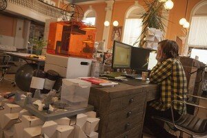 3d printing at a desk in an orange office