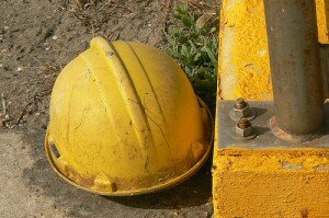yellow hard hat next to concrete and dirt
